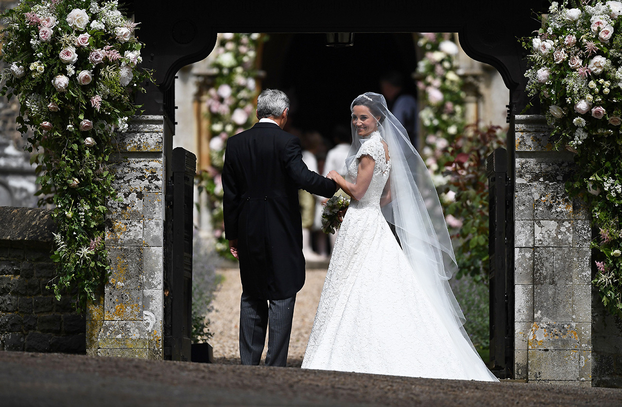 Pippa Middleton, (R) is escorted by her father Michael Middleton, as she arrives for her wedding to James Matthews at St Mark's Church in Englefield, west of London, on May 20, 2017. Pippa Middleton hit the headlines with a figure-hugging outfit at her sister Kate's wedding to Prince William but now the world-famous bridesmaid is becoming a bride herself. Once again, all eyes will be on her dress as the 33-year-old marries financier James Matthews on Saturday at a lavish society wedding where William and Kate's children will play starring roles. / AFP PHOTO / POOL / Justin TALLIS (Photo credit should read JUSTIN TALLIS/AFP/Getty Images)